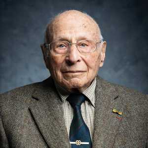 In memoriam Max Wolff (1926–2025)

Met verdriet, maar vooral met diepe dankbaarheid voor zijn blijvende betekenis, nemen we afscheid van meneer Wolff, onze geliefde Max.

Max was een graag geziene eregast in Wageningen. Niet alleen vanwege zijn geschiedenis als bevrijder, maar ook om zijn heldere inzichten, humor en zijn warme aanwezigheid. Zijn betrokkenheid bij onze stad en onze programma’s was oprecht en bijzonder. Hij stond meerdere keren centraal in programma’s als Vuur van de Vrijheid, Nationale Herdenking Capitulaties 1945, Wereldgesprekken, de Brievenactie en was onderdeel van de Expositie Bevrijdingsverhalen in het Vrijheidskwartier.

Max werd geboren in een Joods gezin in Arnhem. Tijdens de Tweede Wereldoorlog moest hij met zijn ouders onderduiken. Veel van Wolffs Joodse familieleden zijn in de oorlog vermoord door de nazi's. Vastbesloten om bij te dragen aan de bevrijding van Nederland, sloot Max zich op 18-jarige leeftijd aan bij de Prinses Irene Brigade. Vanwege zijn talenkennis werd hij als tolk gedetacheerd bij Britse en Canadese troepen, waaronder het British Royal Engineers Corps. Hij ondersteunde hen bij de bevrijding van Frankrijk, België en Nederland en was getuige van de verschrikkingen in het net bevrijde concentratiekamp Bergen-Belsen.

Max gaf woorden aan wat vrijheid betekent, niet als groot begrip, maar als dagelijkse opdracht. Hij maakte het begrip ‘verschilmaken’ tastbaar en daarmee toegankelijk voor een breed publiek. Omdat hij het terugbracht tot iets kleins en persoonlijks. Geen groot ideaal, maar een keuze in het dagelijks leven, zo liet hij zien: verschil maken kan iedereen. Een boodschap die hij vooral ook wilde overbrengen aan de jongste generatie. Zijn nalatenschap blijft deel van ons en leeft voort in de harten van velen in Wageningen en ver daarbuiten.

Onze gedachten zijn bij zijn familie en allen die hem liefhadden.

Namens Wageningen45,

Chris Janssen, directeur